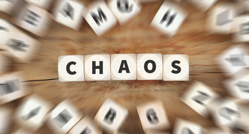 Wooden letter tiles spelling CHAOS on a swirling wood background